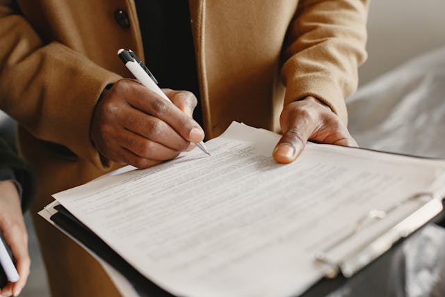 Person using a pen to fill out a form